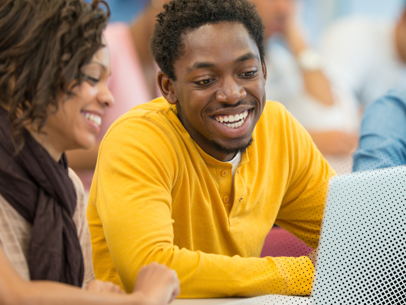 Two young people working together at a laptop